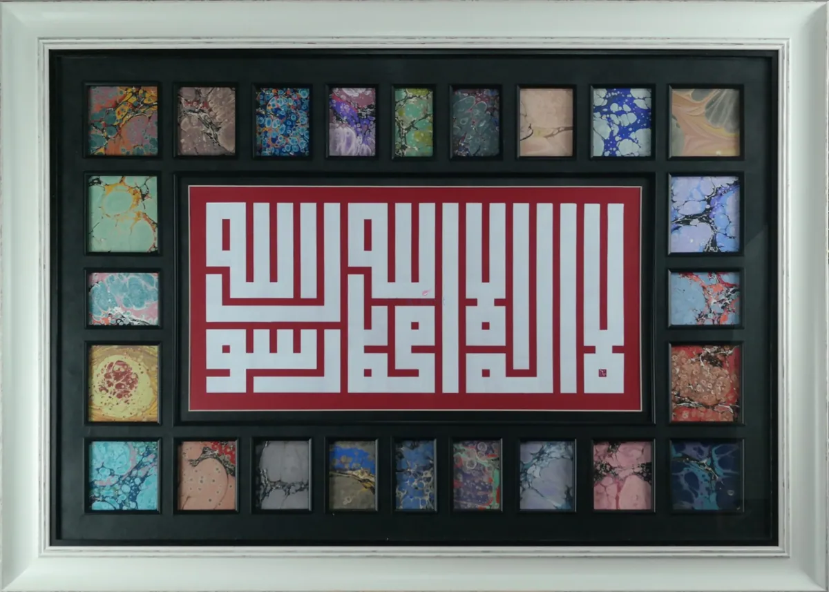 لوحة التهليل بالخط الكوفي المربع مرصّعة بالإبرو