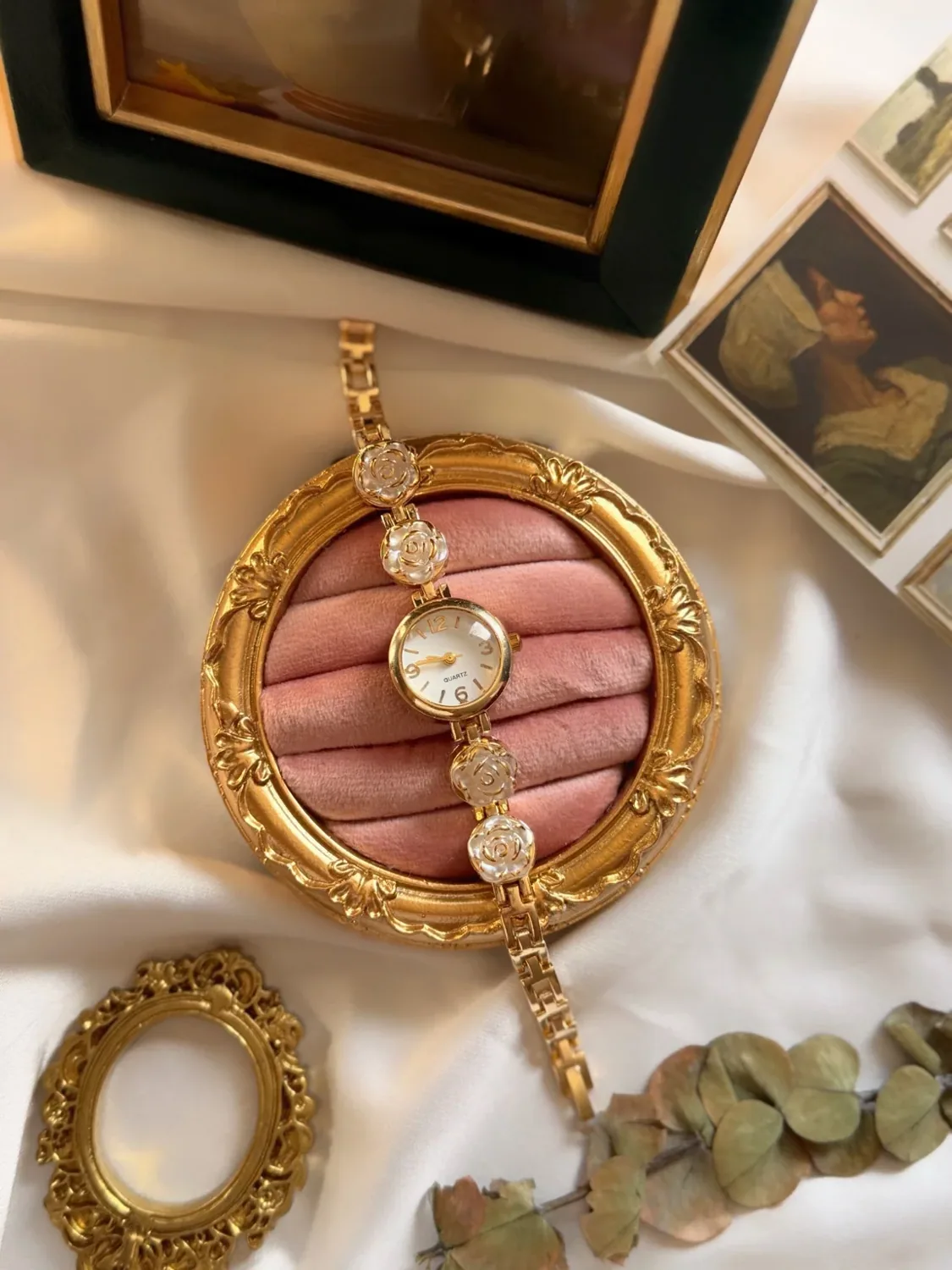 ساعة نسائية ذهبية بميناء أبيض وزخارف ورد