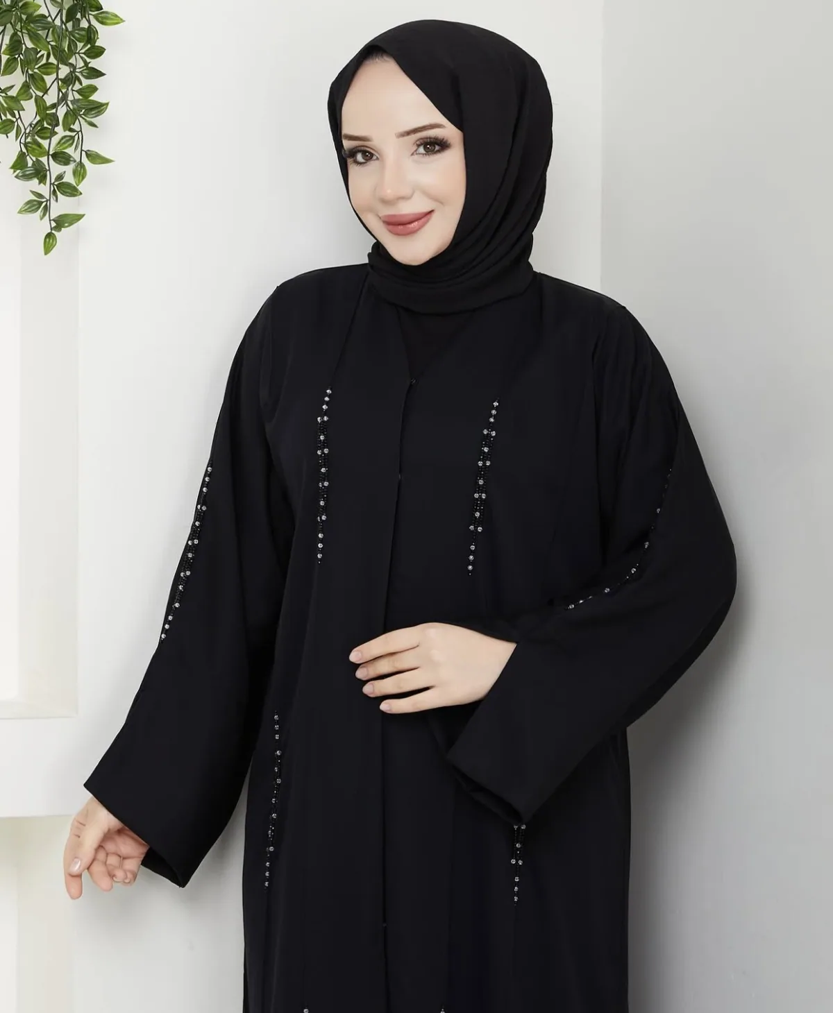 عباءة سوداء بخطوط أحجار على الأكمام