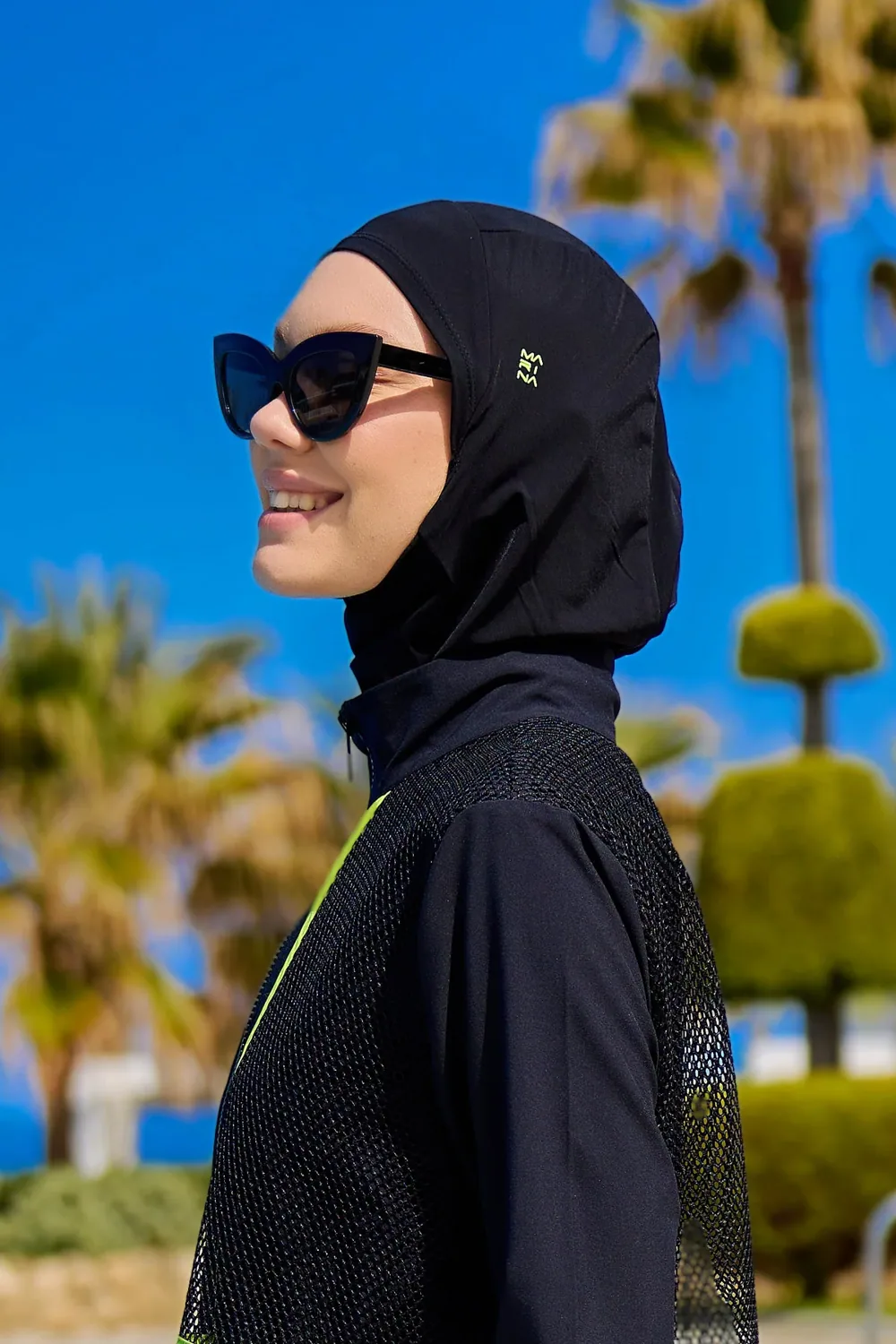 غطاء سباحة رياضي أسود بشعار أخضر يغطي الرقبة - صورة 2